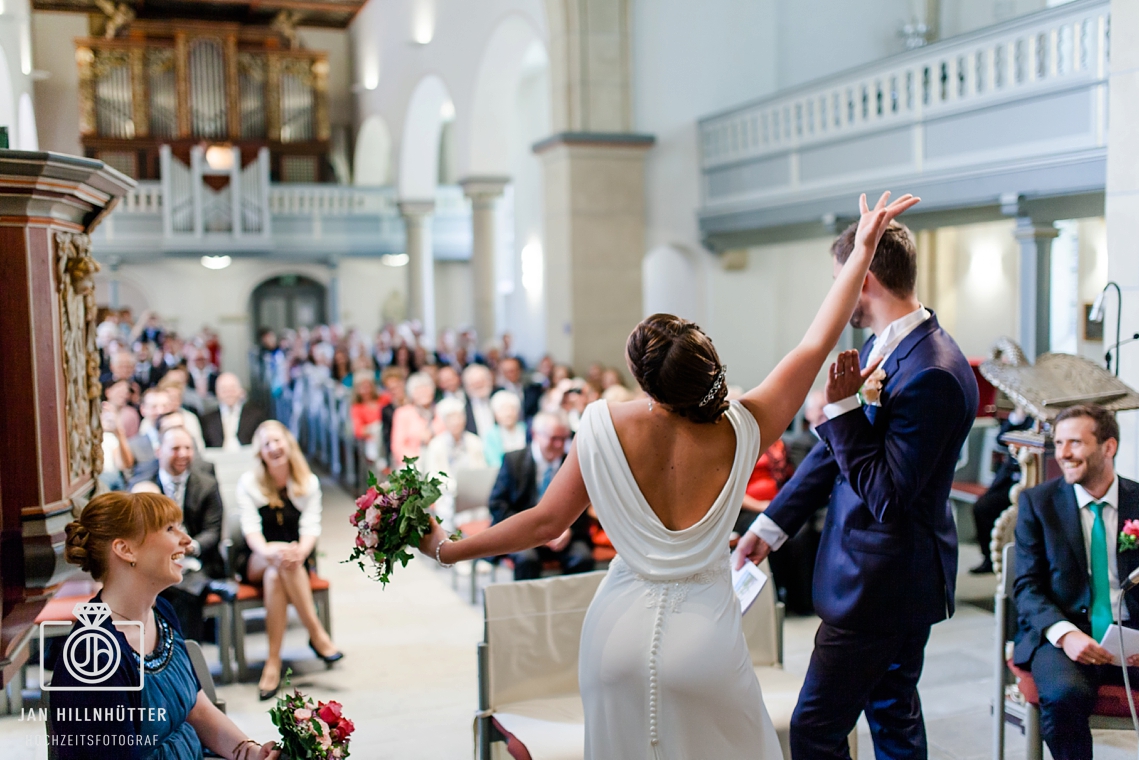 Lustige, tanzende Braut vor dem Altar