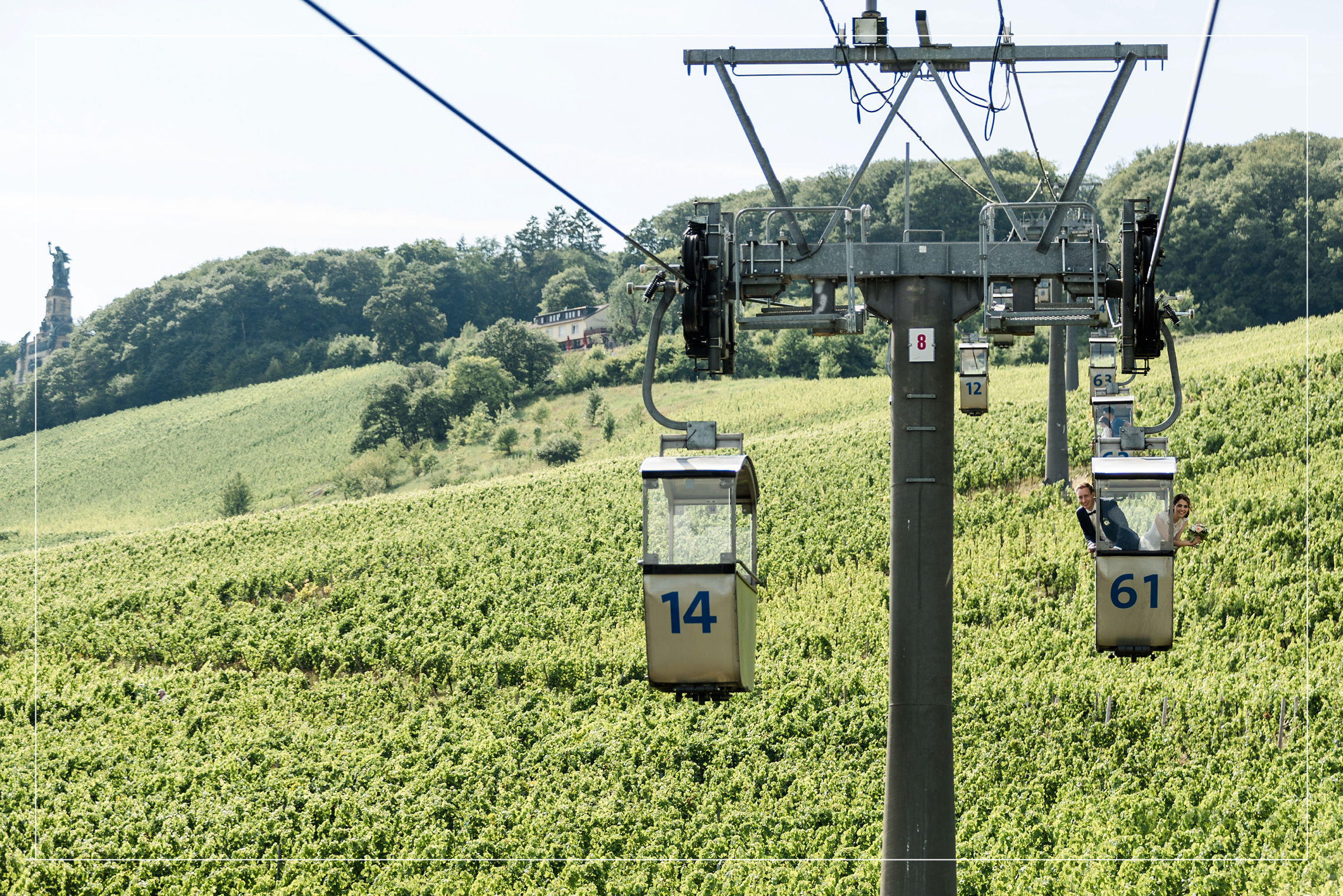 Hochzeitsreportage im Rheingau - das Brautpaar schwebt in der Seilbahn über den Weinbergen von Rüdesheim.