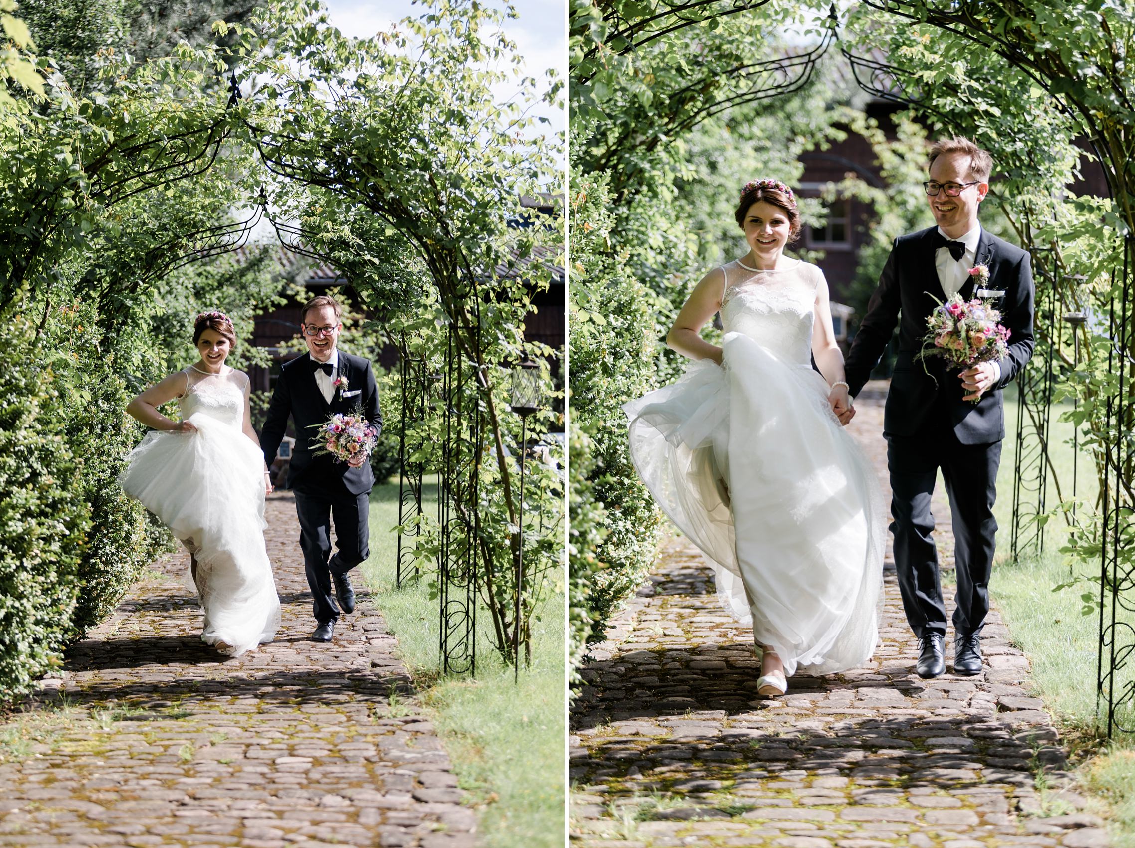 Das Brautpaar rennt in voller Montur einen Weg im Garten des Grenzhof Heidelberg entlang