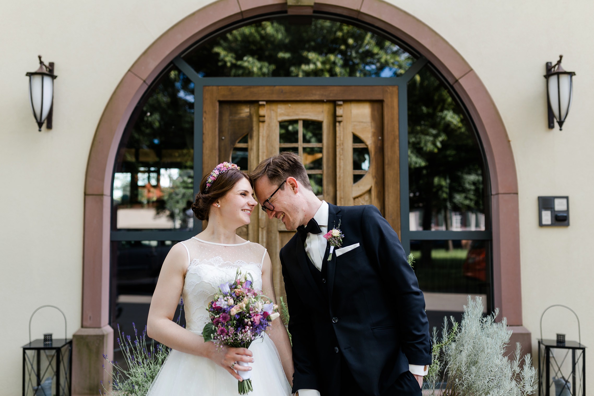 Lustiges Portrait des Hochzeitspaares vor dem Eingang des Grenzhofes in Heidelberg