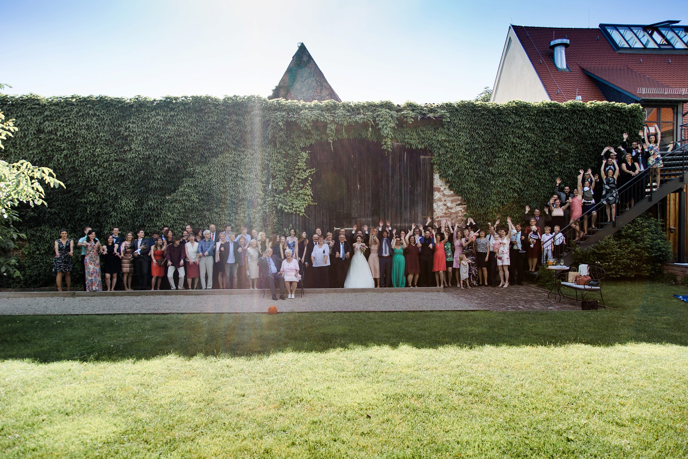 Die gesamte Hochzeitsgesellschaft macht eine La Ola im Garten des Grenzhofes Heidelberg
