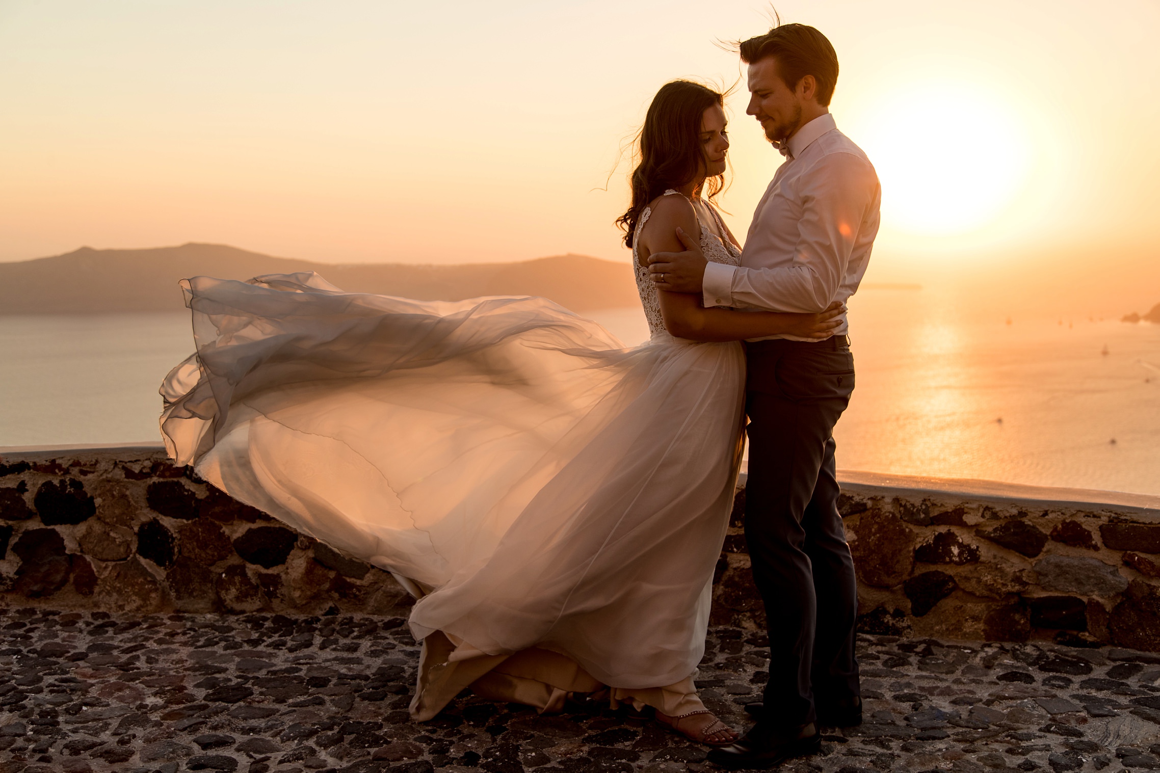 Fliegendes Brautkleid während des Sonnenunterganges beim After-Wedding-Shooting Santorini.