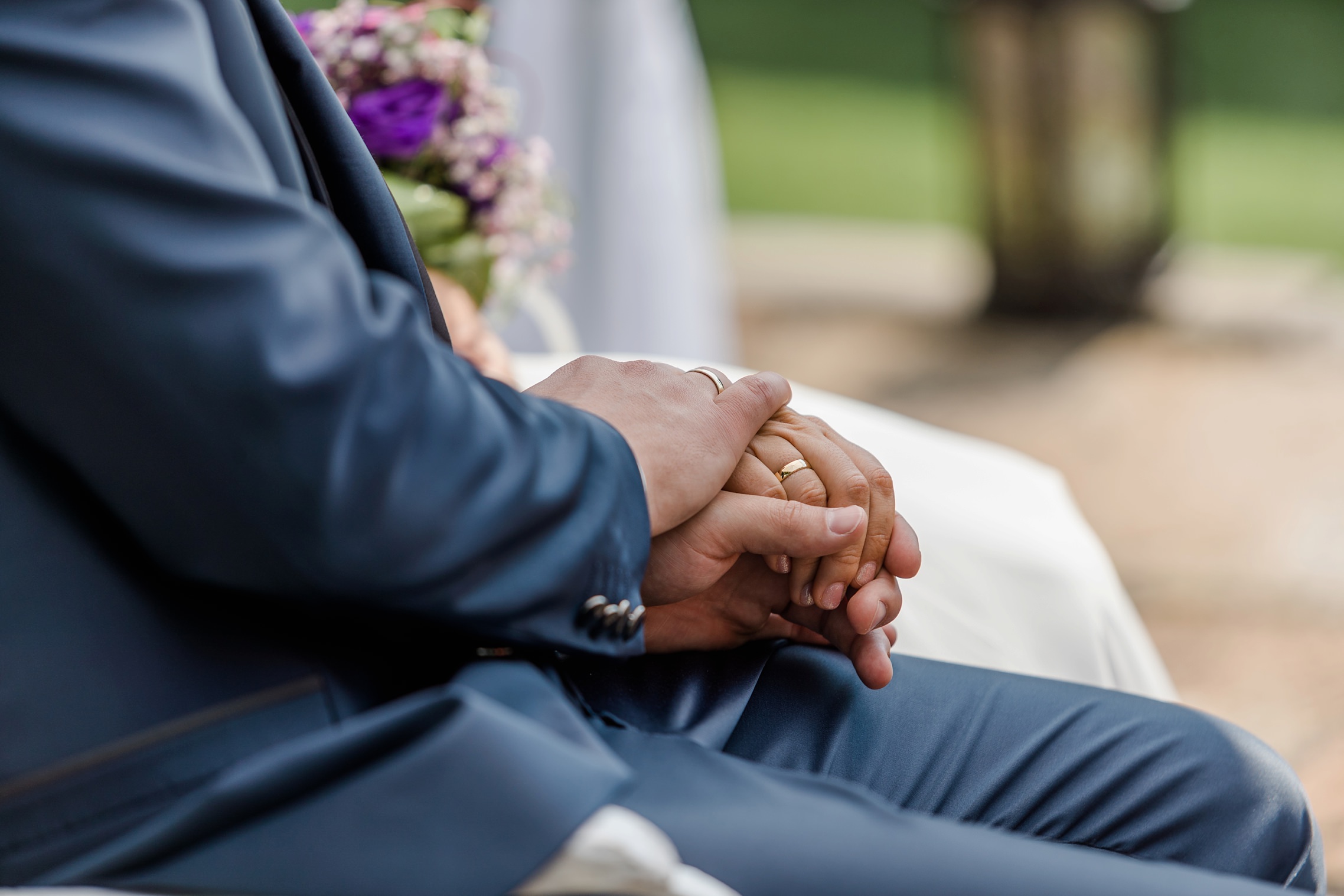 Detailaufnahme der Hände des Brautpaares mit den frisch angesteckten Ringen.