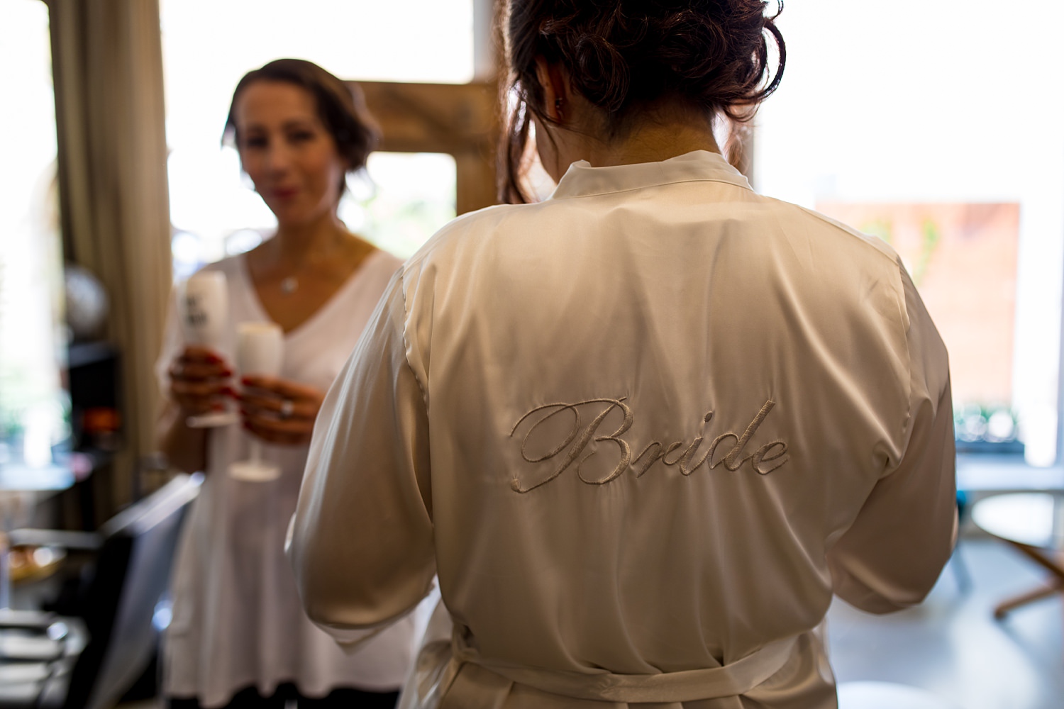 Braut beim Getting Ready im Bademantel mit Aufschrift Bride