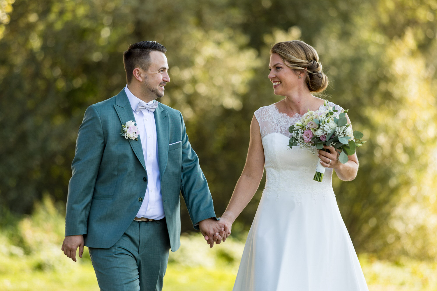 Hochzeitspaar schlendert in der Natur.