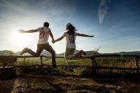 Verlobtes Paar mit Freudensprung